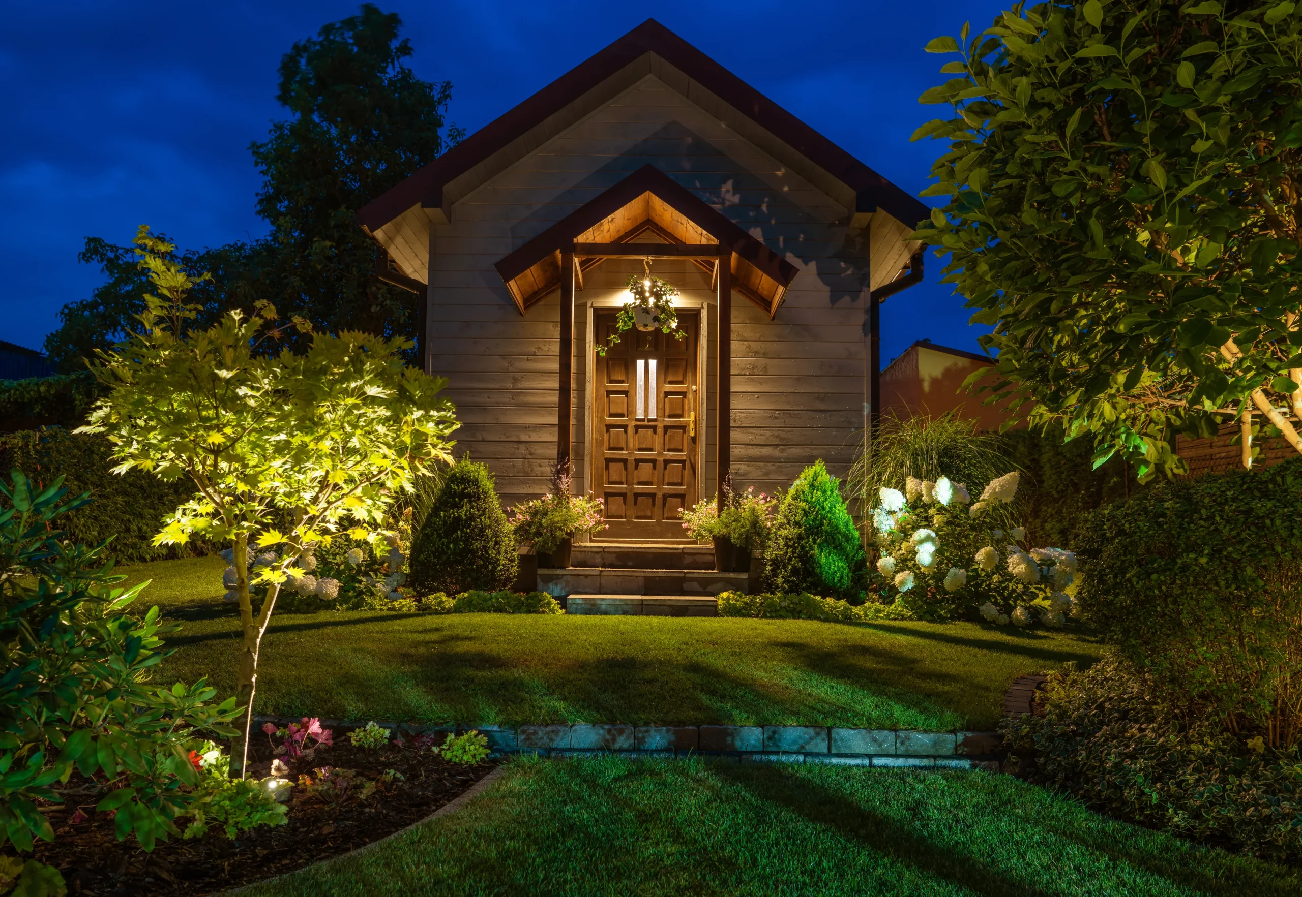 A rustic garden shed with illuminated lighting.