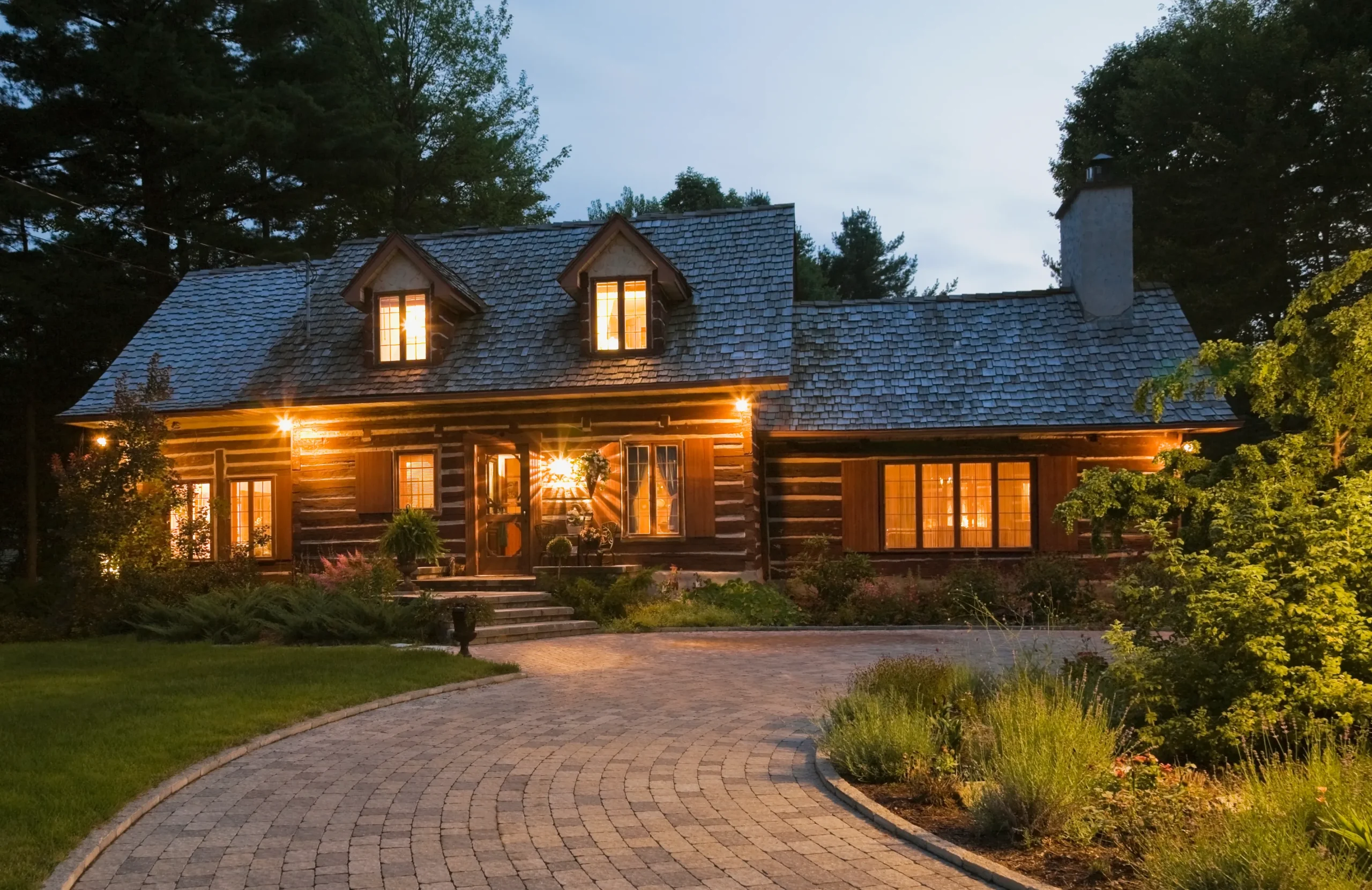 A cottage style log house with a good lighting of LED lights.